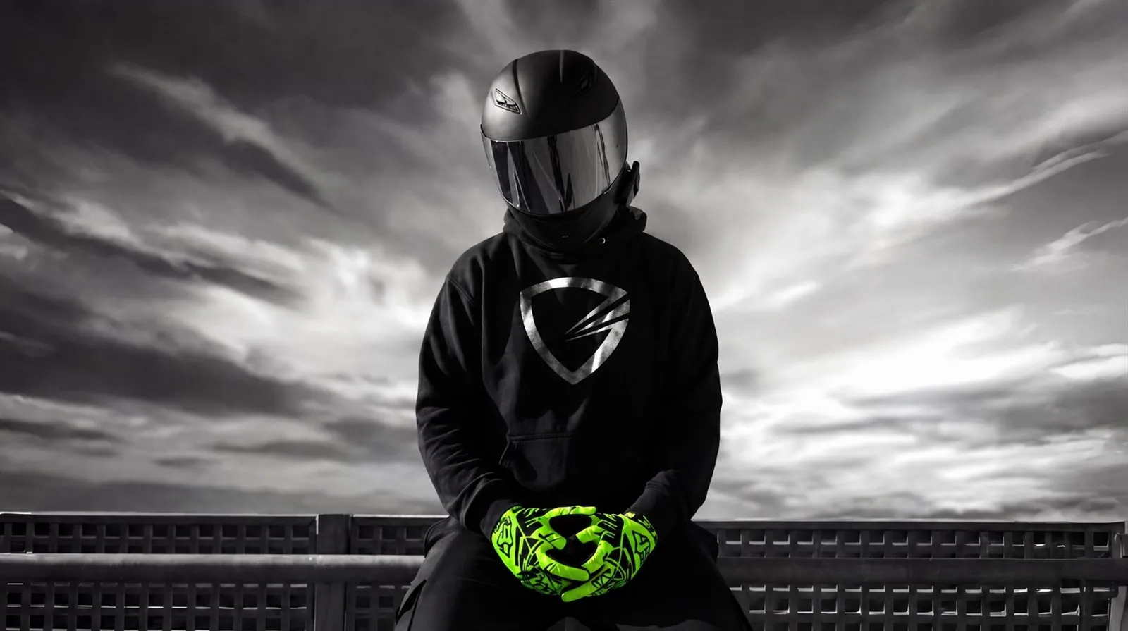 Rider in a Gloves Galore hoodie resting gloved hands on a railing